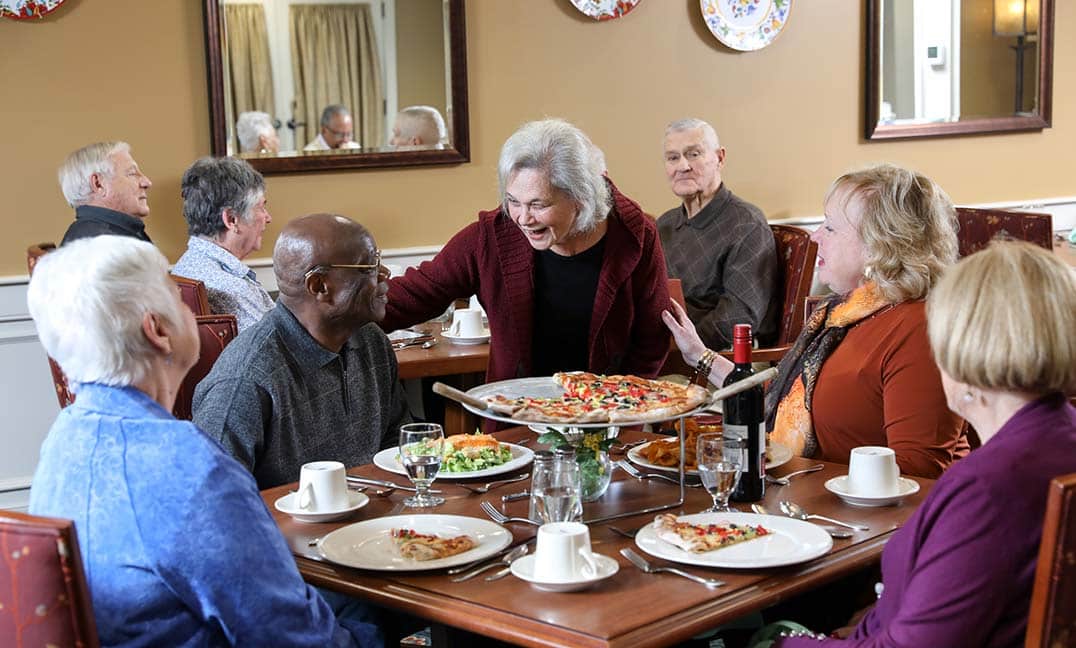 Women greeting group at dinner table